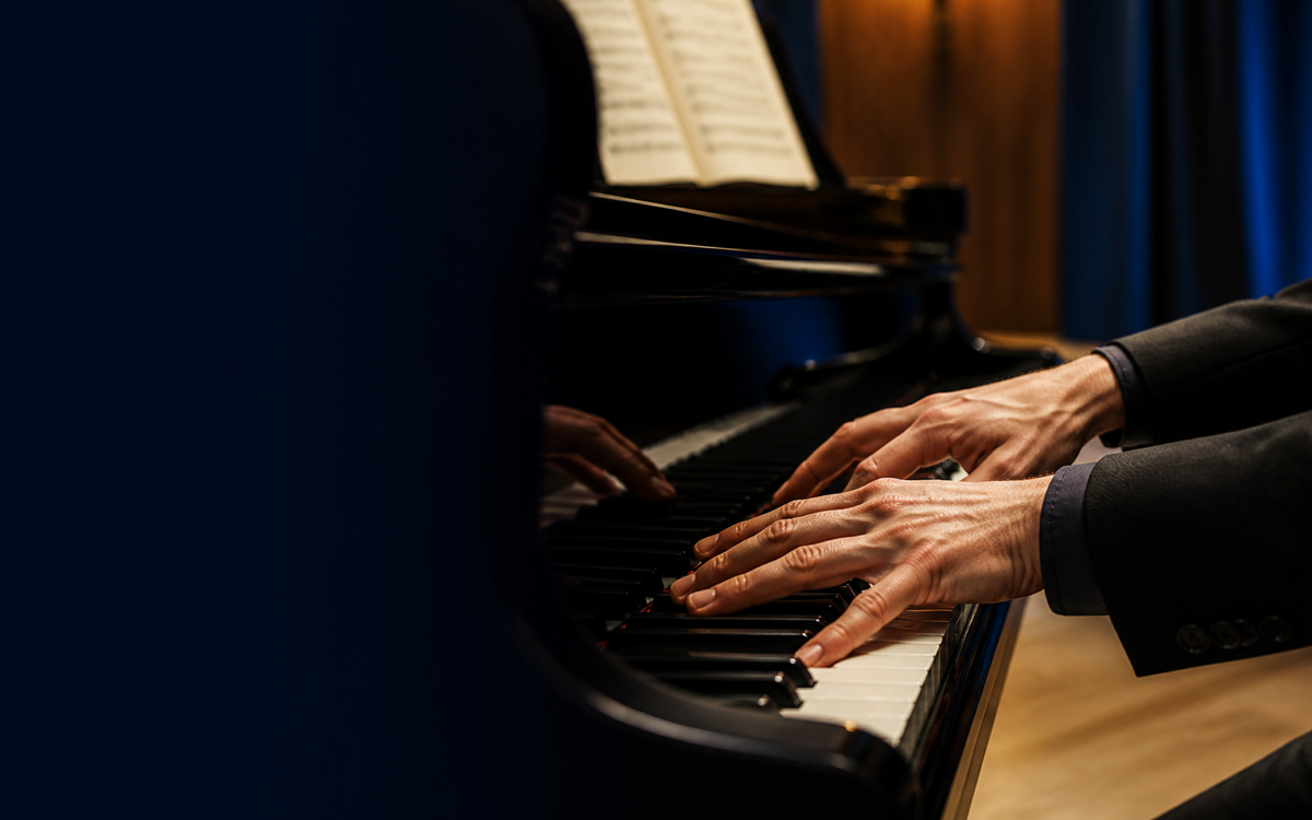Hands playing a piano chord
